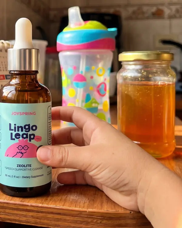 Frasco de Lingo Leap en la cocina junto a un vaso infantil y un frasco de miel